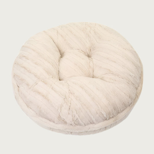 Round, cream colored plush pet bed with textured faux mink fur.