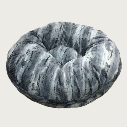 Round, plush pet bed made with faux fur in shades of black, gray and cream in a subtle striped pattern.