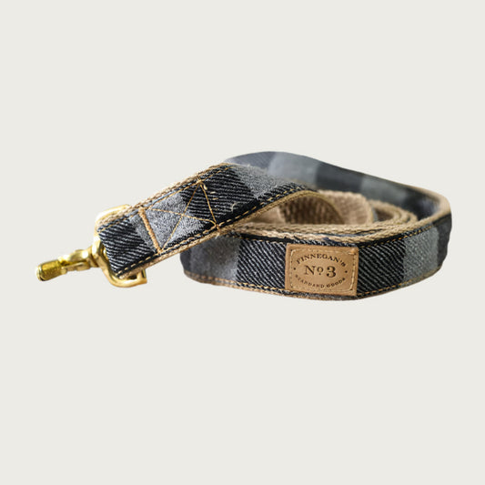 Grey and black buffalo plaid dog leash with brass clasp.