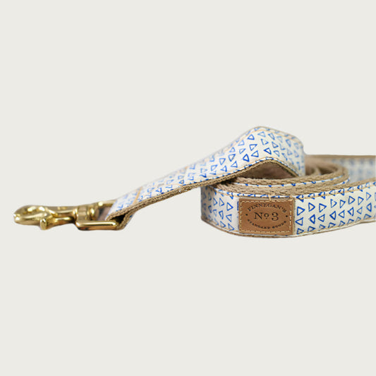 Dog leash with small, blue outlined triangle, repeating pattern with a creamy white base color.