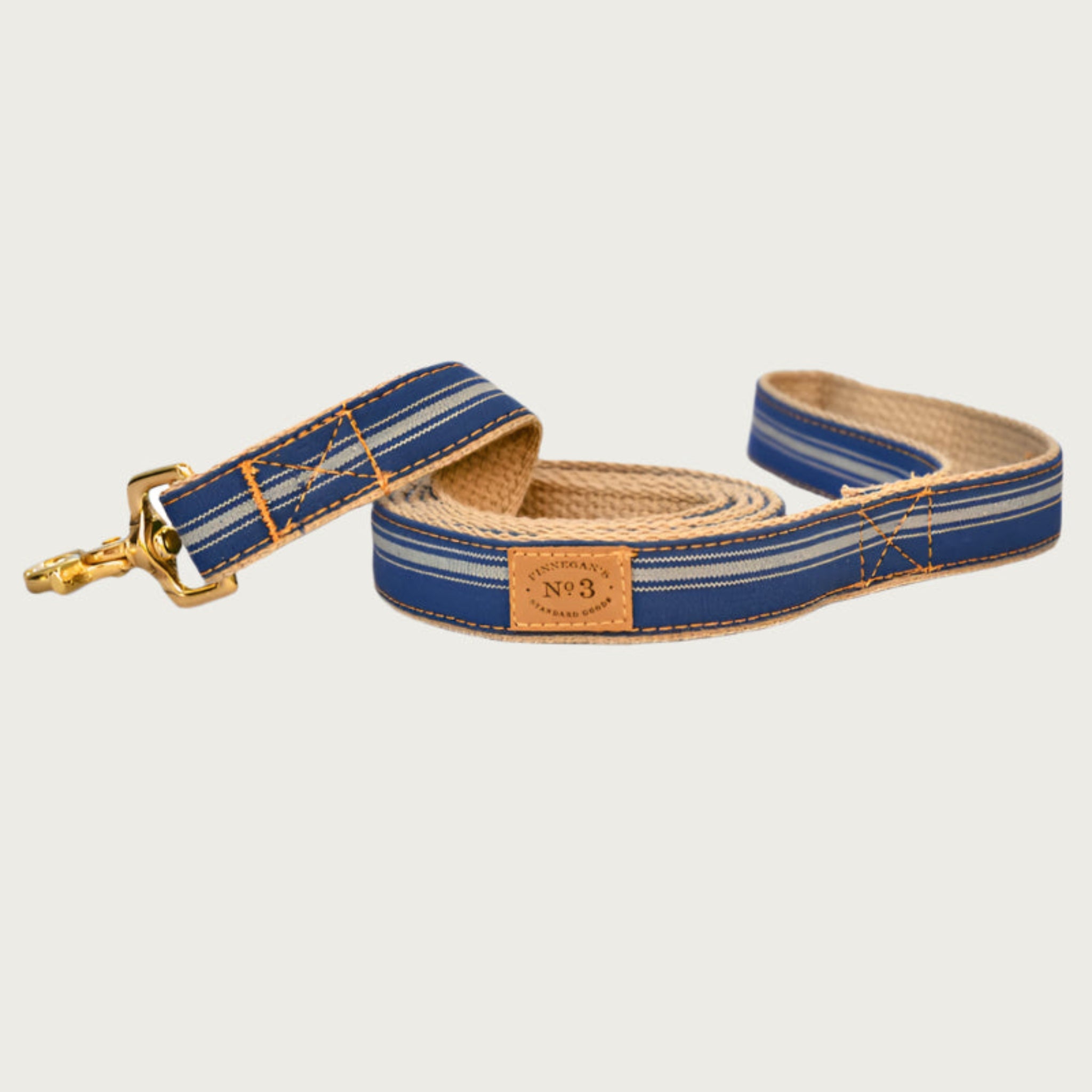 Dark denim blue dog leash with tan vertical stripes of different widths.
