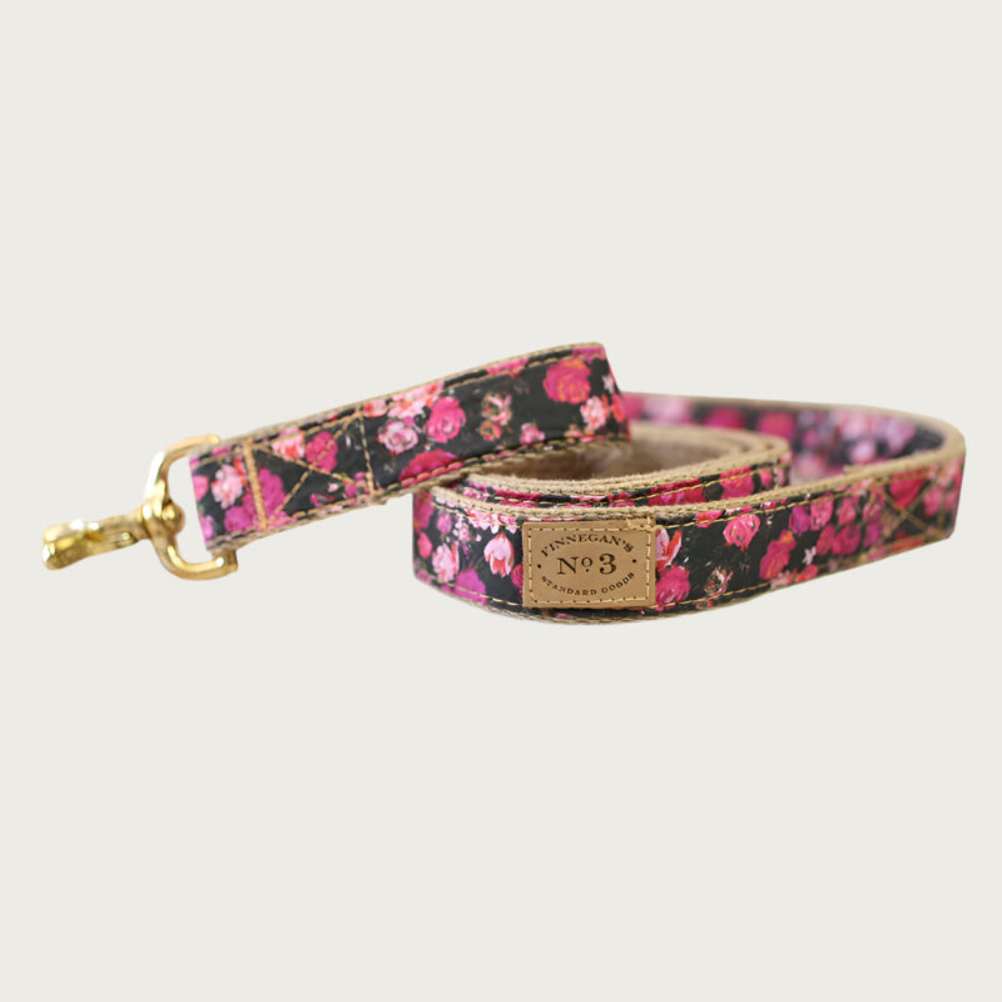 Dog leash with black base color and rose pattern in shades of pink and red.