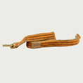 Load image into Gallery viewer, Flannel dog leash with medium orange base color, with vertical stripe tweed pattern in brown. With brass clasp.
