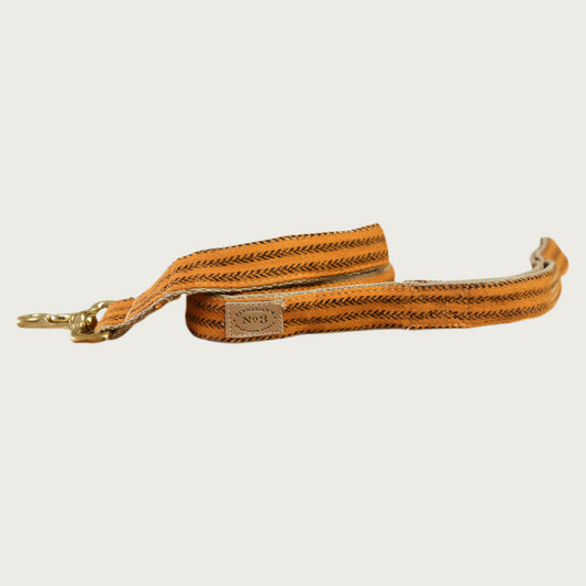 Flannel dog leash with medium orange base color, with vertical stripe tweed pattern in brown. With brass clasp.