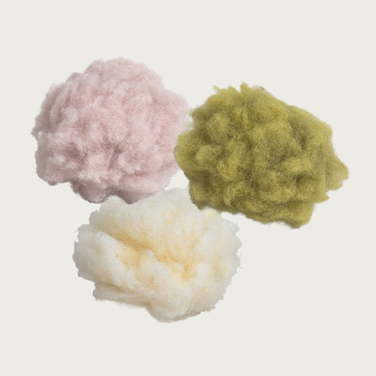 Three fluffy fleece balls, in pink, cream or light green.