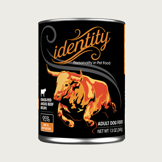 A 13 oz black can of Identity Adult Dog Food. Grass-fed angus beef recipe, with 95% beef & beef broth. Illustration in center is an orange bull.
