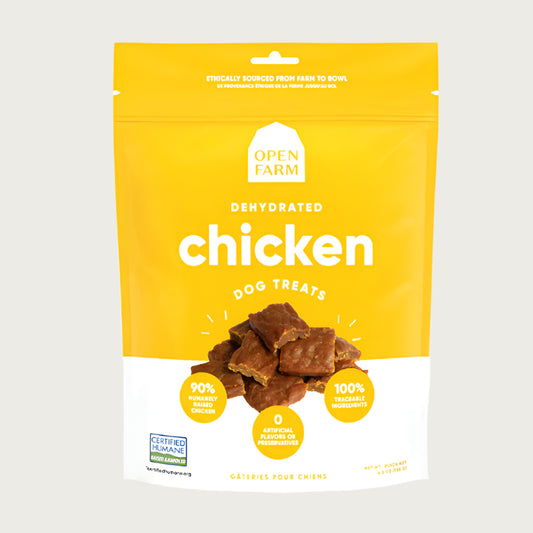 A 4.5 oz yellow & white bag of Open Farm Dehydrated Chicken Dog Treats. Small photo in center shows a close-up of a few of the jerky-style treats.