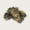 Load image into Gallery viewer, A close-up photo of a small handful of the Open Farm Cod Skins dog treat. They are rectangular gray pieces, about 1"-2" long and 1/4" thick.
