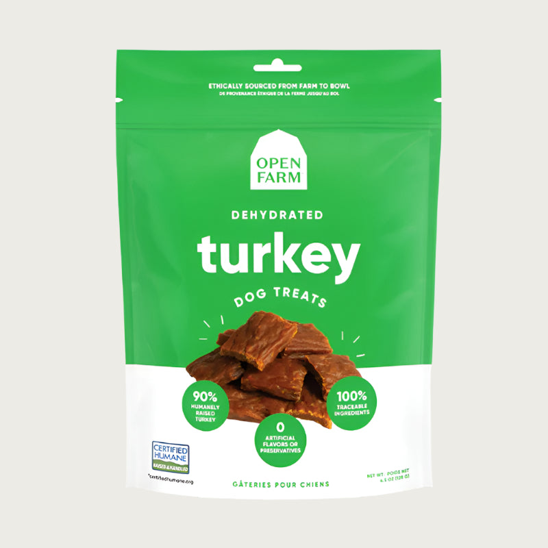 A 4.5 oz green & white bag of Open Farm Dehydrated Turkey Dog Treats. Small photo in center shows a close-up of a few of the jerky-style treats.