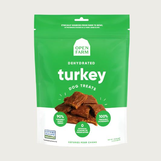 A 4.5 oz green & white bag of Open Farm Dehydrated Turkey Dog Treats. Small photo in center shows a close-up of a few of the jerky-style treats.