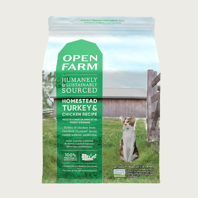 A 4 lb bag of Open Farm Grain Free Turkey & Chicken Recipe cat food. Humanely raised and sustainably sourced. A photo of a brown & white cat standing in a field on a farm covers the bag, with a green bar behind the white text to highlight it.