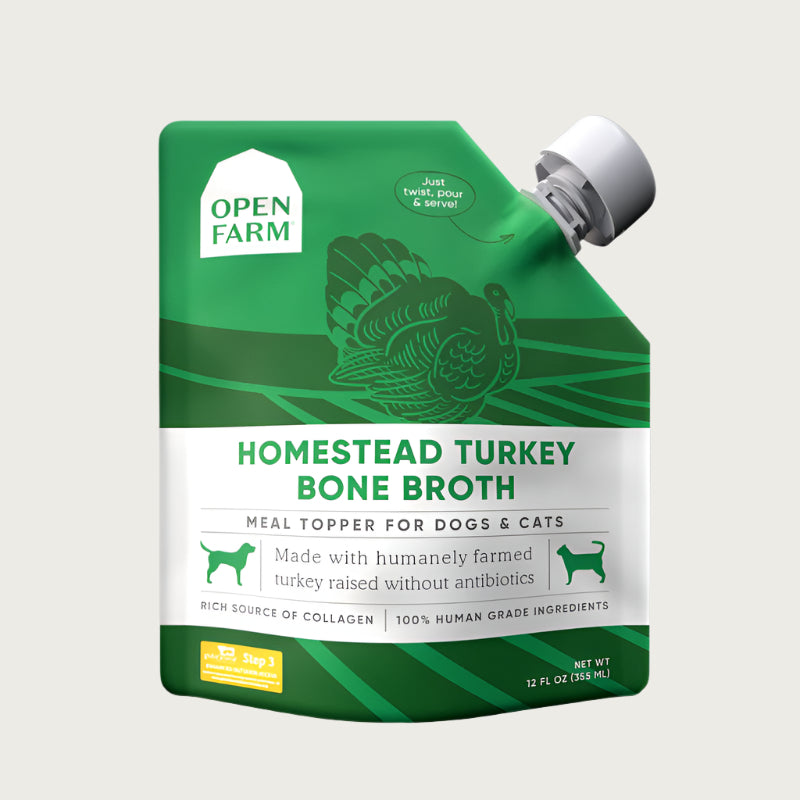 A 12 oz green & white pouch with spout, of Open Farm Homestead Turkey Bone Broth Meal Topper for Dogs & Cats. 