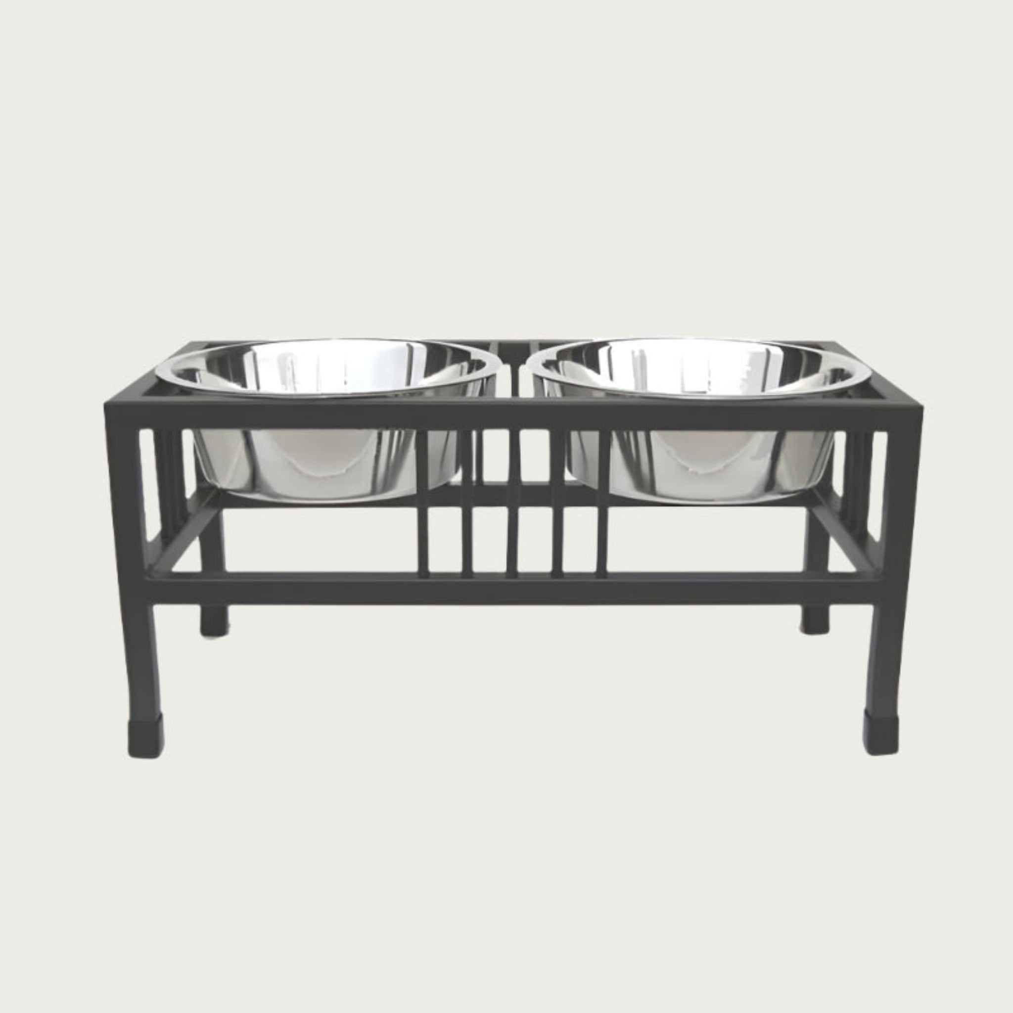 Elevated pet feeder with two metal bowls on a black stand.