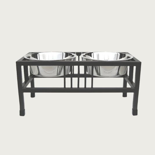 Elevated pet feeder with two metal bowls on a black stand.