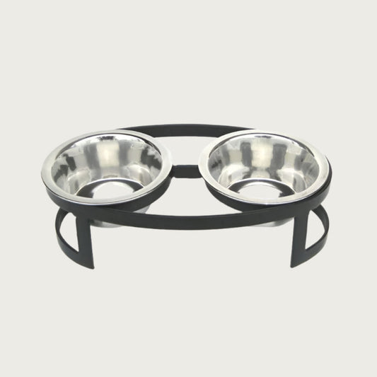 Small, oval shaped, elevated pet food bowl stand in black, with two stainless steel bowls.