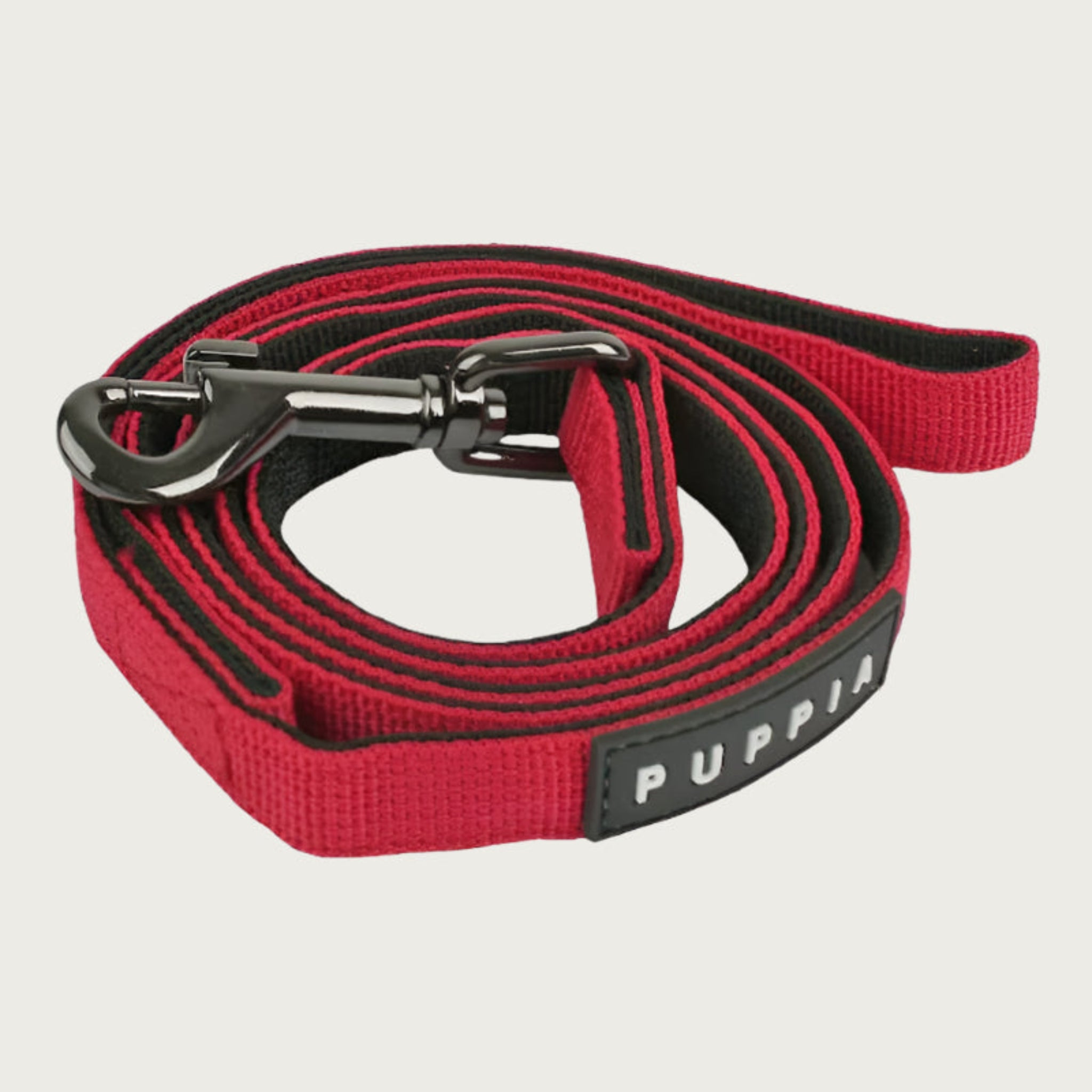 Red & black dog leash with dark metal clip and black & white Puppia tag.