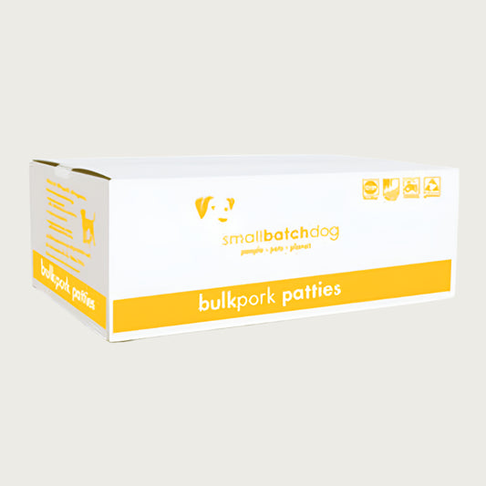 A yellow and white box of Smallbatch pork batch recipe, frozen raw dog food. This 18 pound bulk box contains 36 patties.