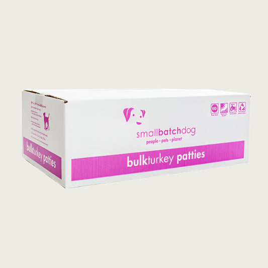 A hot pink and white box of Smallbatch turkey batch recipe, frozen raw dog food. This 18 pound bulk box contains 36 patties.