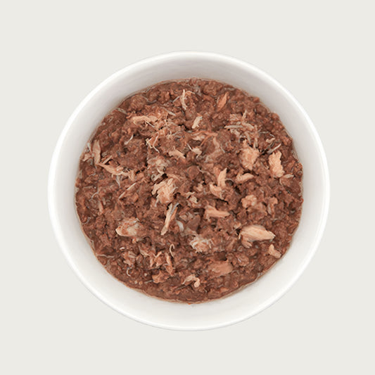 Close-up photo of a dish of Tiki Cat Ahi Tuna & Crab Recipe. Food is a reddish brown color, and is primarily a minced texture with lighter colored shreds of crab throughout. 