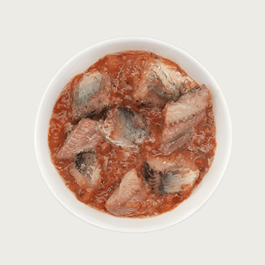 Close-up photo of a dish of Tiki Cat Sardine Cutlets Recipe. Large sardine chunks are in a thick, reddish color broth.