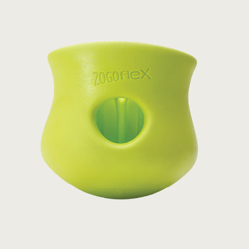 Granny Smith (lime green) colored Toppl toy. It has a cupped shape, with a slight indent on the top 1/3 of the toy, just under its lip. There is a round opening in the center, and the top of the toy is completely open. There are vertical ridges inside it.