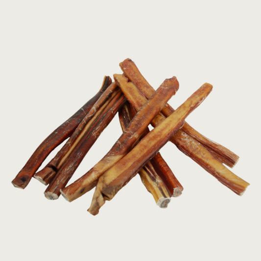 Stack of bully sticks dog chews to show natural variations in shape and color.