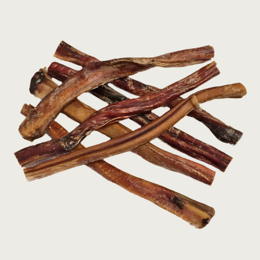 Stack of thick bully stick dog chews, to show natural variations in shape and color.
