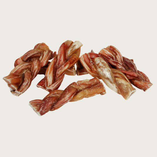 A stack of multiple 6 in long braided bully dog chews, grouped to show natural color & size variation.
