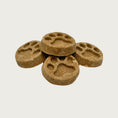 Load image into Gallery viewer, Closeup of five Wet Nose Apple Honey Paw Print treats. They are brown, round, about 2" wide, and embossed with a paw print shape.
