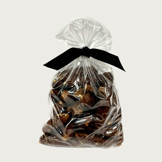 13 oz clear resealable bag of Wet Nose exclusive, Beef Smokies dog treats, tied with black ribbon. Product inside is reddish/brown links. 