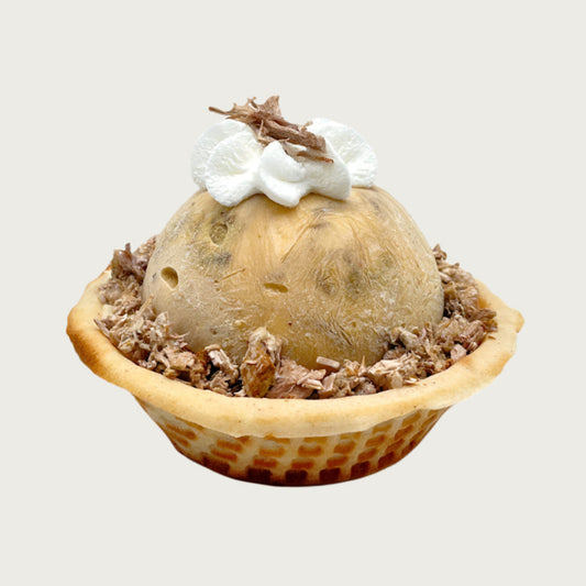 Doggie Ice cream dessert with a scoop of tan colored ice cream in a waffle bowl, topped with a dollop of whipped cream and shredded beef.