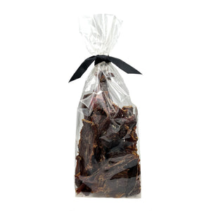 7 oz clear cellophane bag of Wet Nose exclusive Buffalo Jerky dog treats, tied with black ribbon. Product inside is brown, rectangular shaped strips.