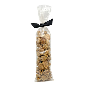 2.25 oz clear cellophane, tube-shaped bag of Wet Nose exclusive Bunny Drops dog treats, tied with black ribbon. Treats inside are pale brown in color, and shaped like pebbles of various sizes.