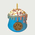 Load image into Gallery viewer, Cup shaped, blue dog toy, with whipped cream layered on top. There are multicolored sprinkles and a candle on top of the whipped cream. Dripping about halfway down the sides of the toy, is an edible, decorative drip design moving down from the rim of the toy.
