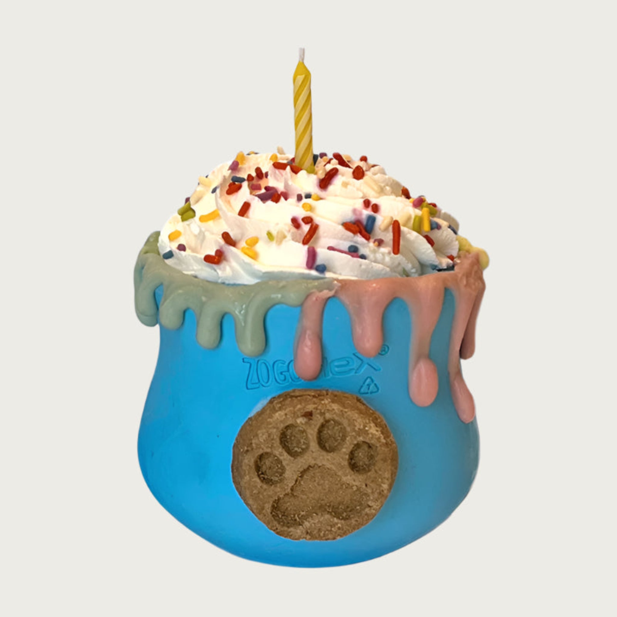 Cup shaped, blue dog toy, with whipped cream layered on top. There are multicolored sprinkles and a candle on top of the whipped cream. Dripping about halfway down the sides of the toy, is an edible, decorative drip design moving down from the rim of the toy.