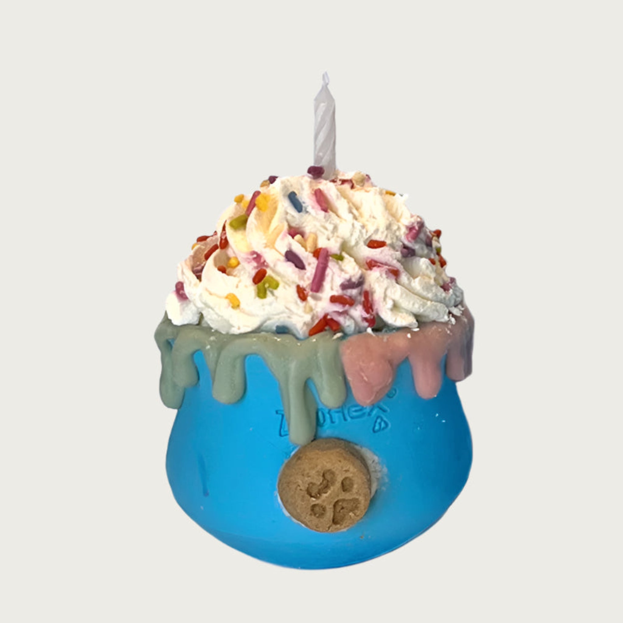 Cup shaped, blue dog toy, with whipped cream layered on top. There are multicolored sprinkles and a candle on top of the whipped cream. Dripping about halfway down the sides of the toy, is an edible, decorative drip design moving down from the rim of the toy.