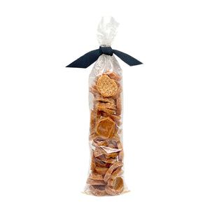 3 oz clear cellophane, tube-shaped bag of Wet Nose exclusive Chicken Nuggets dog treats, tied with black ribbon. Stacked coin-shaped treats inside are a pale orangey-tan color.