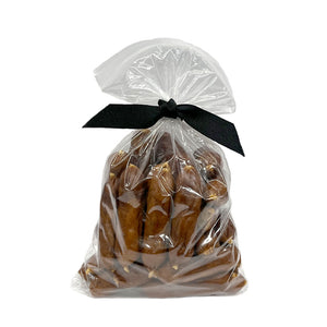 7 oz clear resealable bag of Wet Nose exclusive, Duck Smokies dog treats, tied with black ribbon. Product inside is medium brown colored links. 