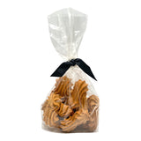 10 oz clear, cellophane bag of Wet Nose exclusive, Goobers dog treats, tied with black ribbon. Visible inside are 3" long, tan cookies with swirl texture on top.