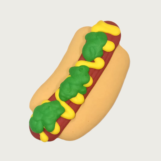 Decorated dog cookie that looks like a hot dog with mustard and relish on a bun.