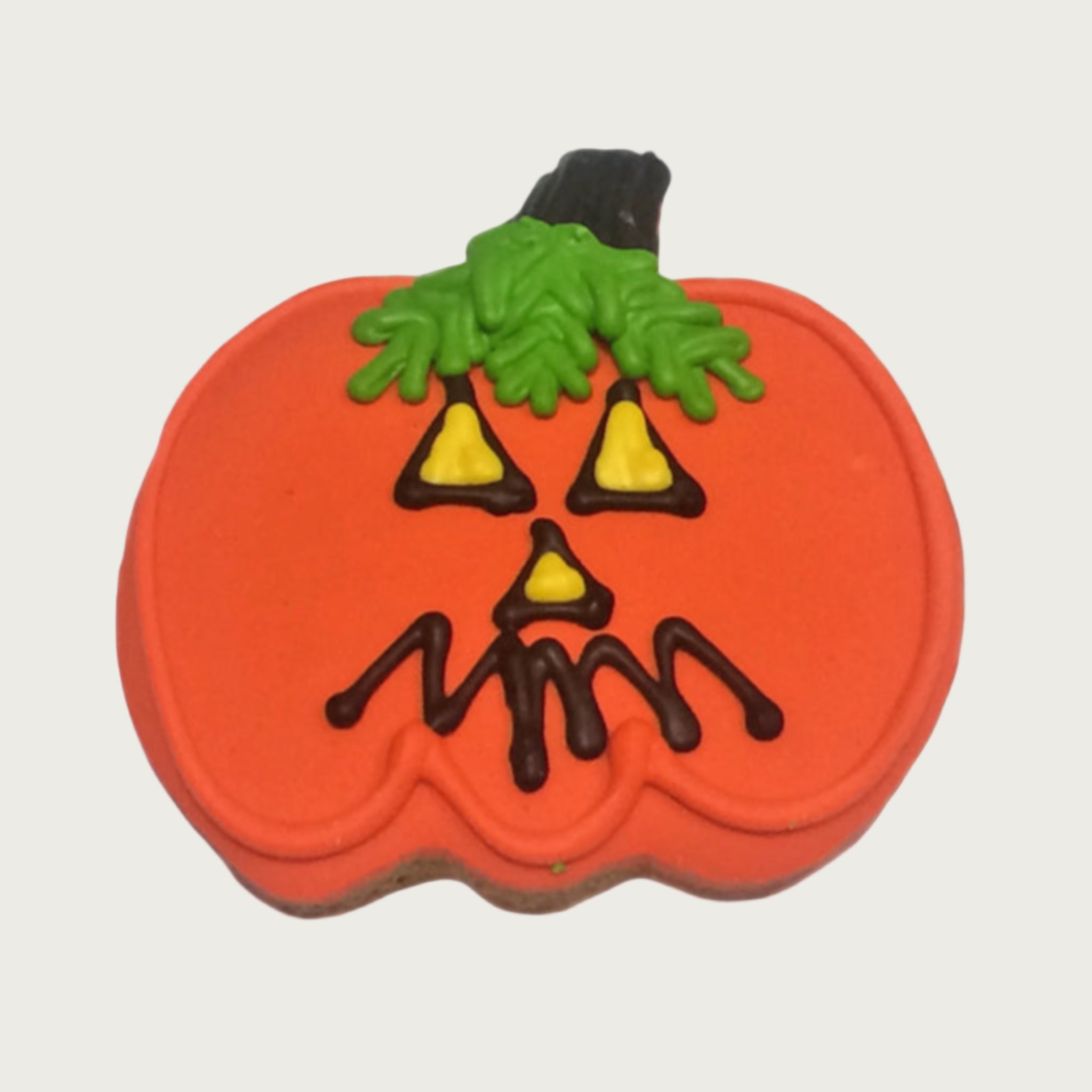 Pumpkin-shaped dog cookie with a jack-o'-lantern face.