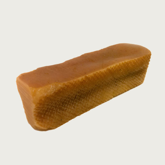 Irregular, oblong-rectangular shaped dog chew that is dark tan in color.