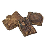 Closeup photo of a small pile of Wet Nose Moo Munch dog treats. Product is varying sizes of square shaped, brown treats, ranging from approximately 2" - 4" wide.