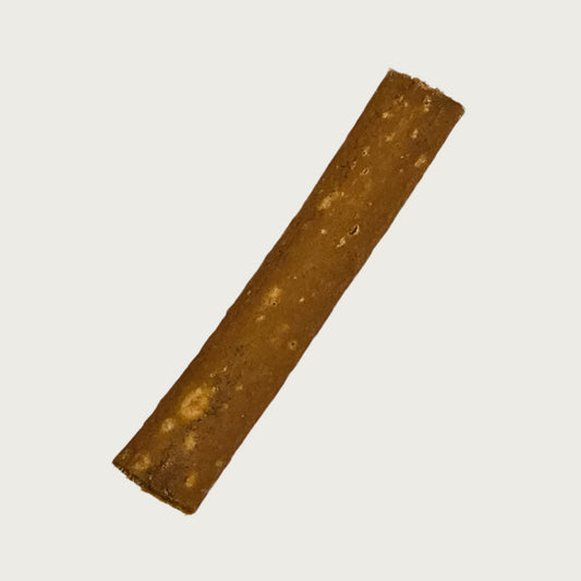 A single piece of ostrich jerky. It is thin, rectangular shaped, and medium brown in color