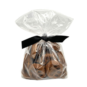 10 oz clear, resealable bag of Wet Nose exclusive, Peanut Butter Paw Print dog treats, tied with black ribbon. Visible inside are 1.5"- 2" sized brown round cookies with embossed paw print.