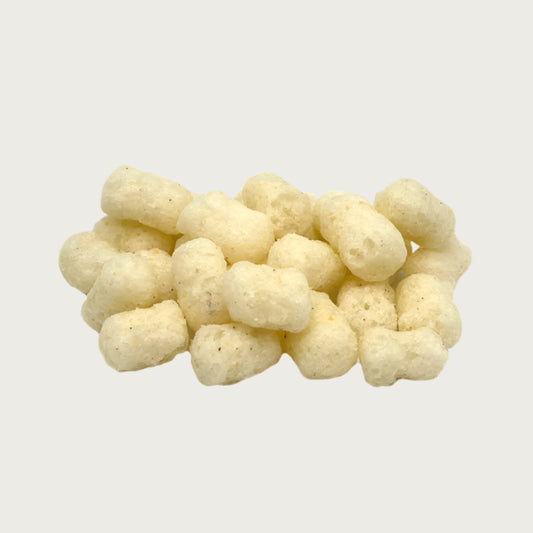 Close-up photo of a small pile of Wet Nose Pooch Puffs dog treats. They are ivory colored, about 1"-1.5" long, and similar in size to small tater tots. They look airy, like Cheetos puffy cheese snacks.