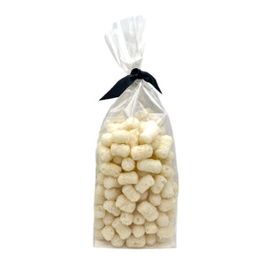 4 oz clear cellophane bag of Wet Nose exclusive Pooch Puffs dog treats, tied with black ribbon. Treats inside are ivory colored, and look like small tater tots.