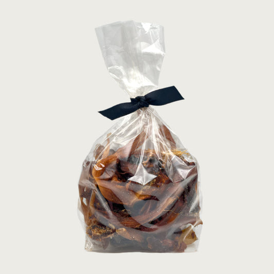 8 oz clear cellophane bag of Wet Nose exclusive Road Runner Stix dog treats, tied with black ribbon. Product inside is brown, rectangular shaped strips.