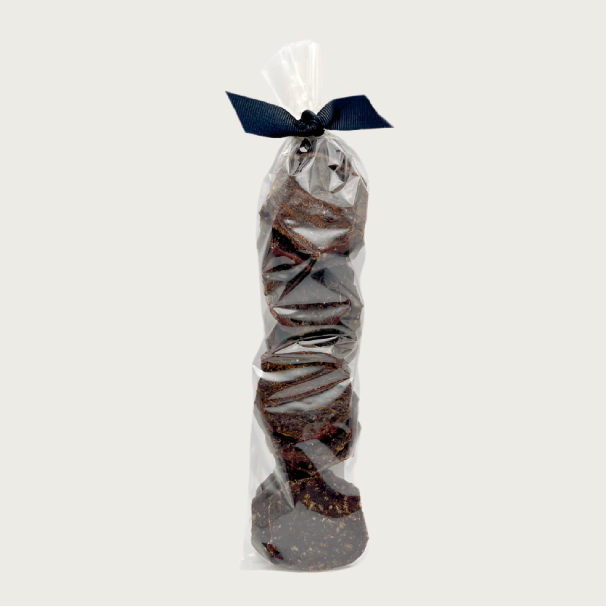 Clear cellophane bag of 15 count Wet Nose exclusive Sliders dog treats, tied with black ribbon. Product inside is round, brown discs.