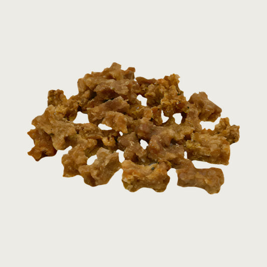 Close-up photo of a small pile of Wet Nose Teeny Meaties dog treats. They are tiny, brown, bone-shaped treats, about 1/2" wide and 1/4" thick.